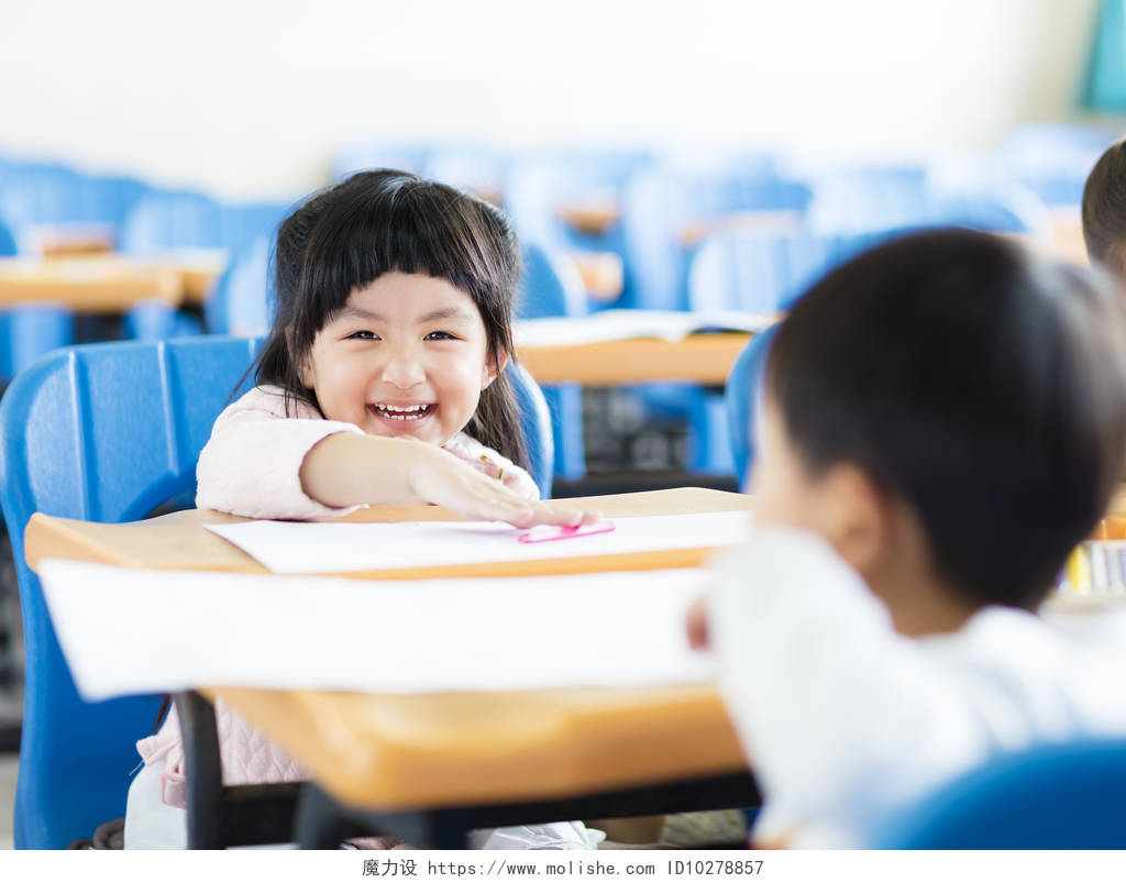 快乐的小女孩学生在教室里微笑的小女孩
